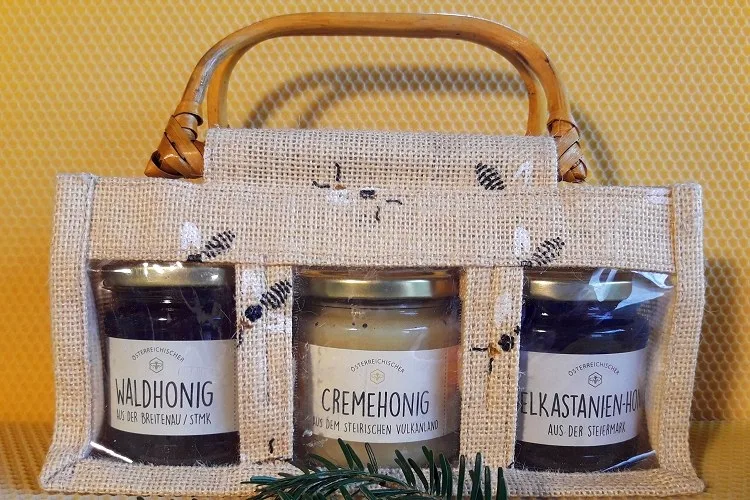 Jutetasche mit drei Honiggläsern darin, die Etiketten nennen Waldhonig, Cremehonig und Edelkastanien-Honig